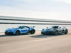 Ein blauer und ein grauer Bugatti fahren auf der Autobahn nebeneinander.
