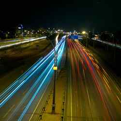 Die Lichter der fahrenden Autos auf der Autobahn bei Nacht.