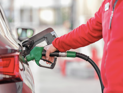 Eine Person tankt ein Auto.