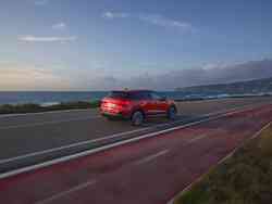 Ein roter Audi SQ2 fährt eine Küstenstraße entlang