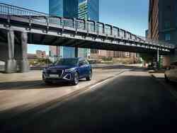 Ein dunkelblauer Audi Q2 fährt durch eine Stadt