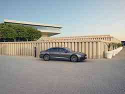 Seitenansicht eines grauen Audi A8, der an einer Ladesäule lädt