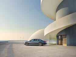 Seitenansicht einer Audi A8 Limousine neben einem futuristischen Gebäude