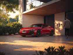 Ein roter Audi e-tron GT lädt an einer Wallbox