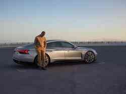 Ein Mann lehnt auf einem silbrigen Audi S e-tron GT