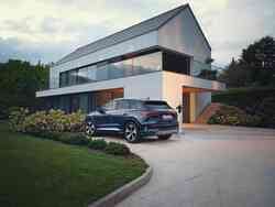 Seitliche Heckansicht eines Audi Q4 e-tron, der vor einem Haus parkt