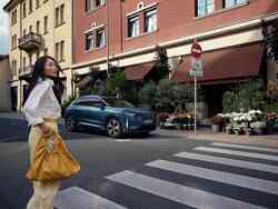 Ein blauer Audi Q4 e-tron parkt vor einem Geschäft