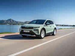 Ein hellgrüner Škoda Elroq fährt an einem See entlang