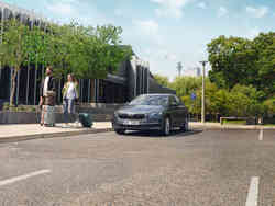 Škoda Octavia Combi parkt am Flughafen, eine Frau und ein Mann gehen daneben mit Koffern