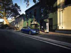 Vor einem Lokal parkt ein Škoda Superb, davor sitzen zwei Personen