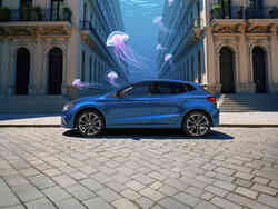 Seitenansicht des SEAT Ibiza vor Gebäude, zwischen denen ein Meer mit Quallen abgebildet ist