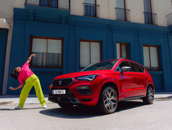 Seitliche Ansicht des SEAT Ateca. Daneben tanzt eine Frau