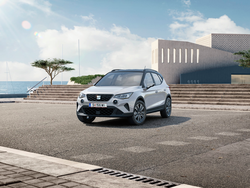 Frontansicht des SEAT Arona, der vor einem Gebäude mit Meerblick steht