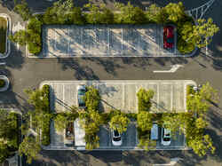Blick von oben auf einen begrünten Parkplatz.