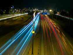 Die Lichter der fahrenden Autos auf der Autobahn bei Nacht.