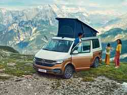 VW California mit Dachzelt auf einem Berg, Mann, Frau und Kind stehen daneben