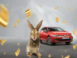 Roter VW Golf Rabbit mit einem Hasen und Goldmünzen im Vordergrund