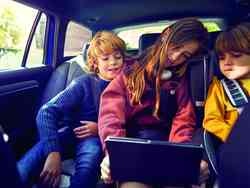 Drei Kinder sitzen auf dem Rücksitz eines Autos und schauen in ein Tablet