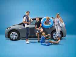 Eine Familie steht vor einem VW ID 3 bepackt mit Schwimmzubehör
