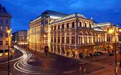 Ein Foto der beleuchteten Wiener Staatsoper bei Nacht.