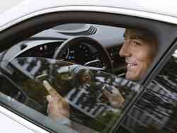 Ein Mann in einem Porsche lächelt durch das halb geöffnete Fenster