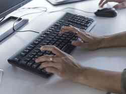 Eine Hand tippt auf einer Computer-Tastatur.