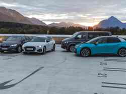 Auf einem Parkplatz stehen ein blauer VW, ein schwarzer VW Bus, ein weißer Audi und ein schwarzer Skoda.