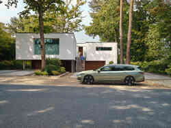 Seitliche Ansicht eines Škoda Superb, der vor einem Haus parkt