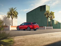 Seitliche Heckansicht des SEAT Leon Kombi, der neben einem Gebäude und Palmen parkt