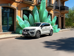 Seitliche Ansicht des SEAT Ateca, der vor grünen Kristallen und einem Gebäude parkt