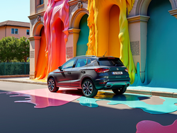Seitliche Heckansicht des SEAT Arona neben einem Gebäude, das mit bunten Farben überzogen ist